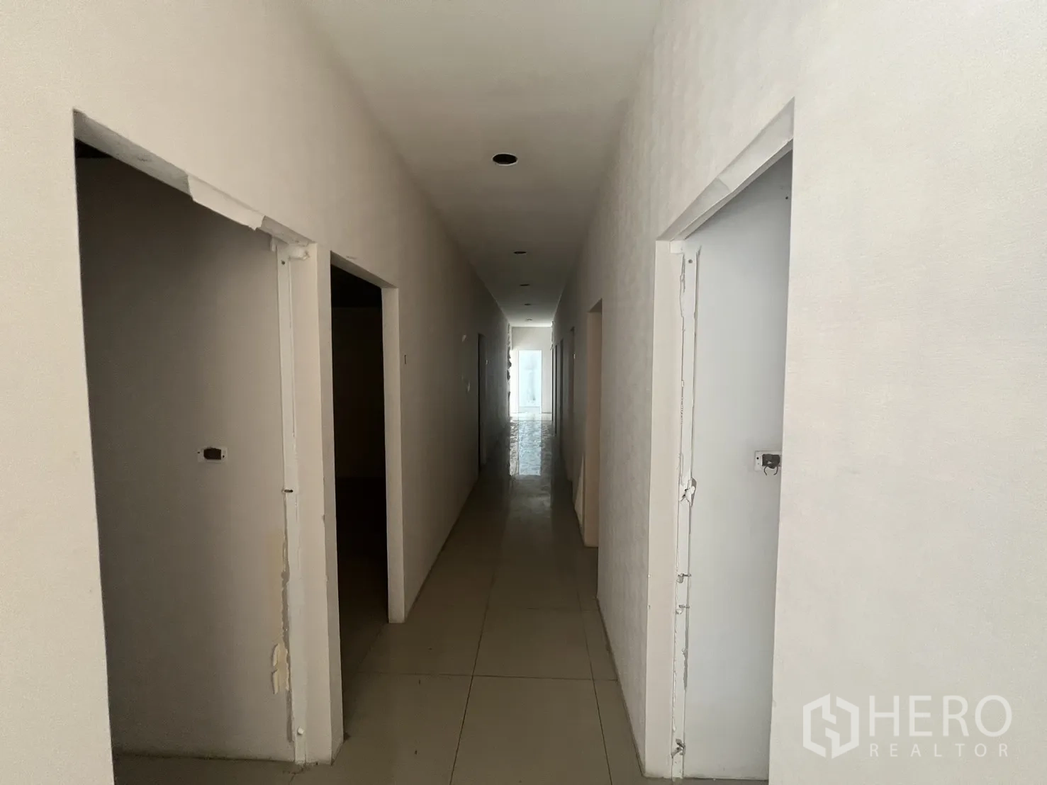 Retail Space for rent in Khlong Toei, Bangkok - Corridor view showing unfinished door frames and recessed downlights.