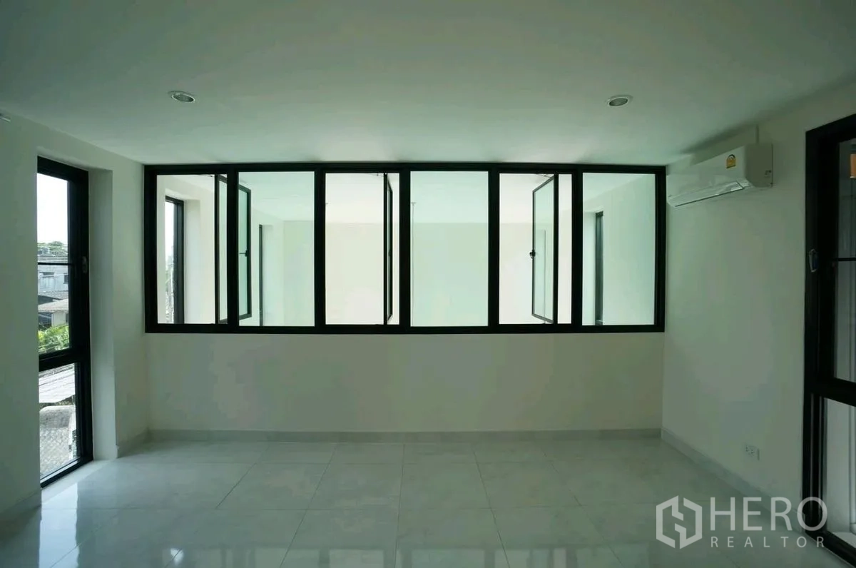 Home Office for rent in Chatuchak, Bangkok - Room with internal glass partition windows and a wall-mounted air conditioner.