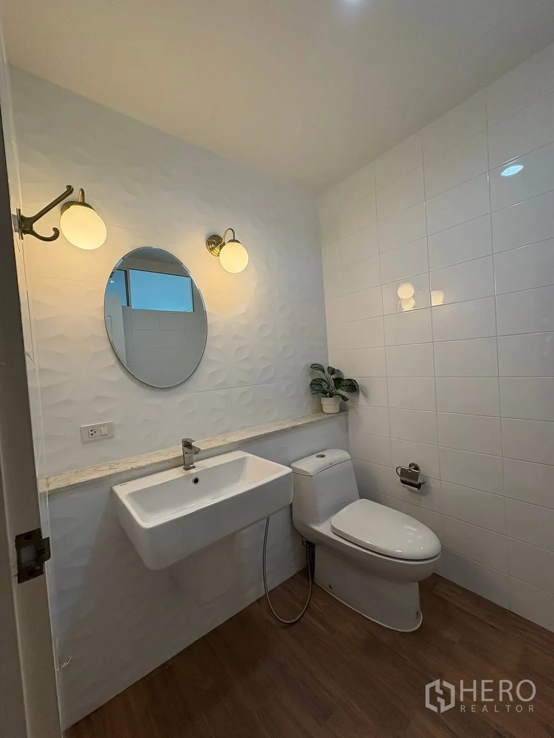 Detached House for rent in Prawet, Bangkok - Powder room with wall sconces, basin and toilet.