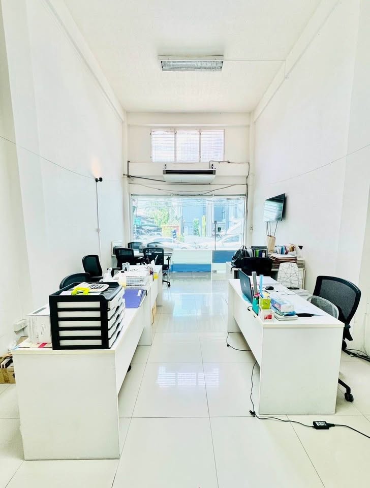 Shophouse for rent in Phra Khanong, Bangkok - Ground-floor office or retail space with high ceiling, glass frontage and workstations.