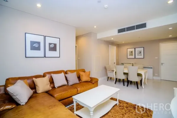 Condominium for rent in Khlong Toei, Bangkok - Open-plan living and dining area with a six-seat dining set, wall art and recessed lighting.