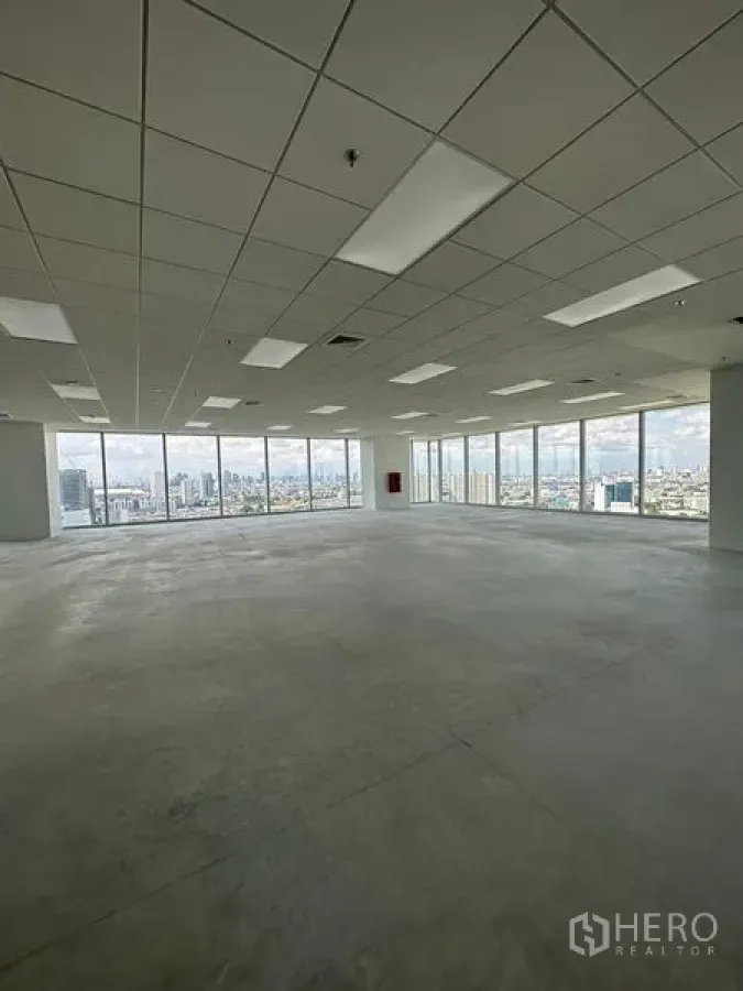 Office Space for rent in Bang Na, Bangkok - Open-plan office floor in Bang Na with drop ceiling, lighting, and full-height windows showcasing a wide Bangkok skyline view.