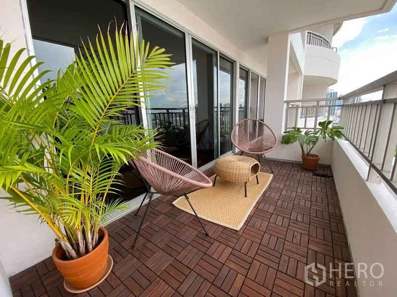Condominium for rent in Sathon, Bangkok - Second balcony angle featuring lounge chairs, outdoor rug and potted palms.