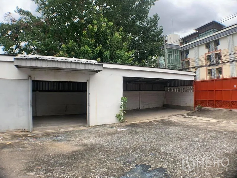 货栈 出租在Lak Si, Bangkok - 带顶停车或装卸棚，多个开放车位与红色围墙大门
