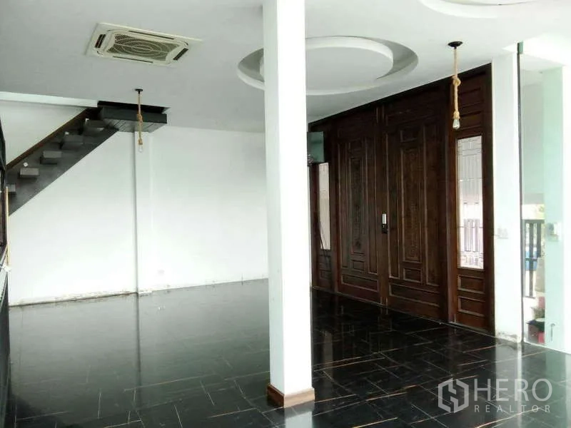 Detached House for sale in Lat Phrao, Bangkok - Entrance hall with black tiled floor and paneled wooden double doors.