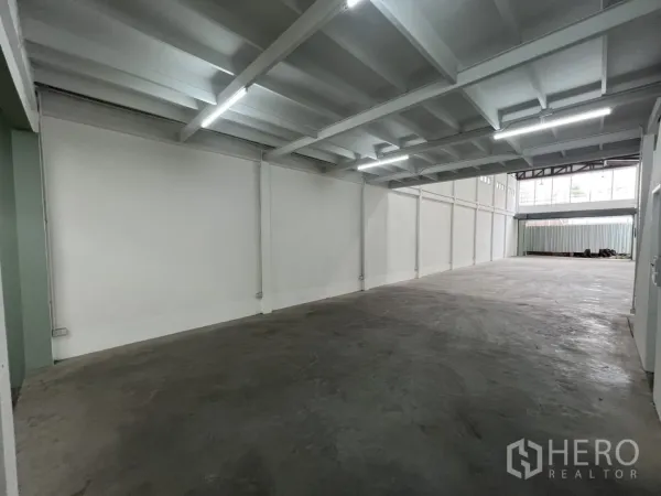 Shophouse for rent in Khlong Toei, Bangkok - Open-plan ground floor space with long span ceiling and bright LED lighting.