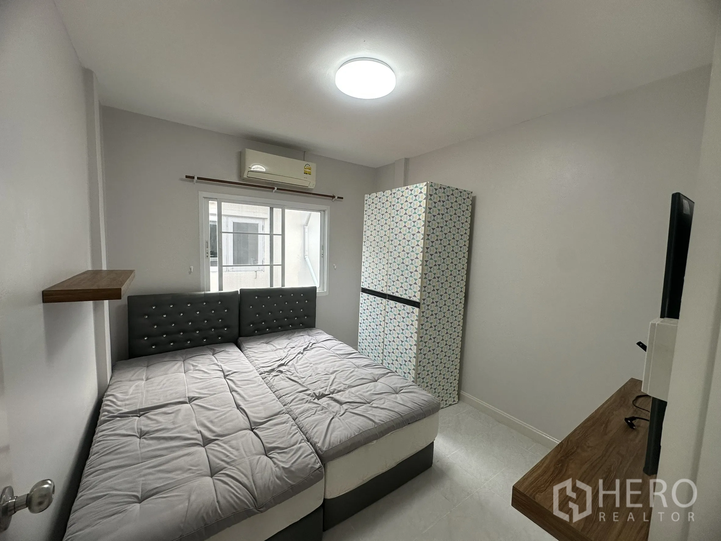 Townhouse for sale in Lam Luk Ka, Pathum Thani - Third bedroom with twin beds, window and wall shelf.