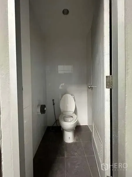 Warehouse for rent in Bang Phli, Samut Prakan - Clean tiled restroom with white toilet and handheld bidet.