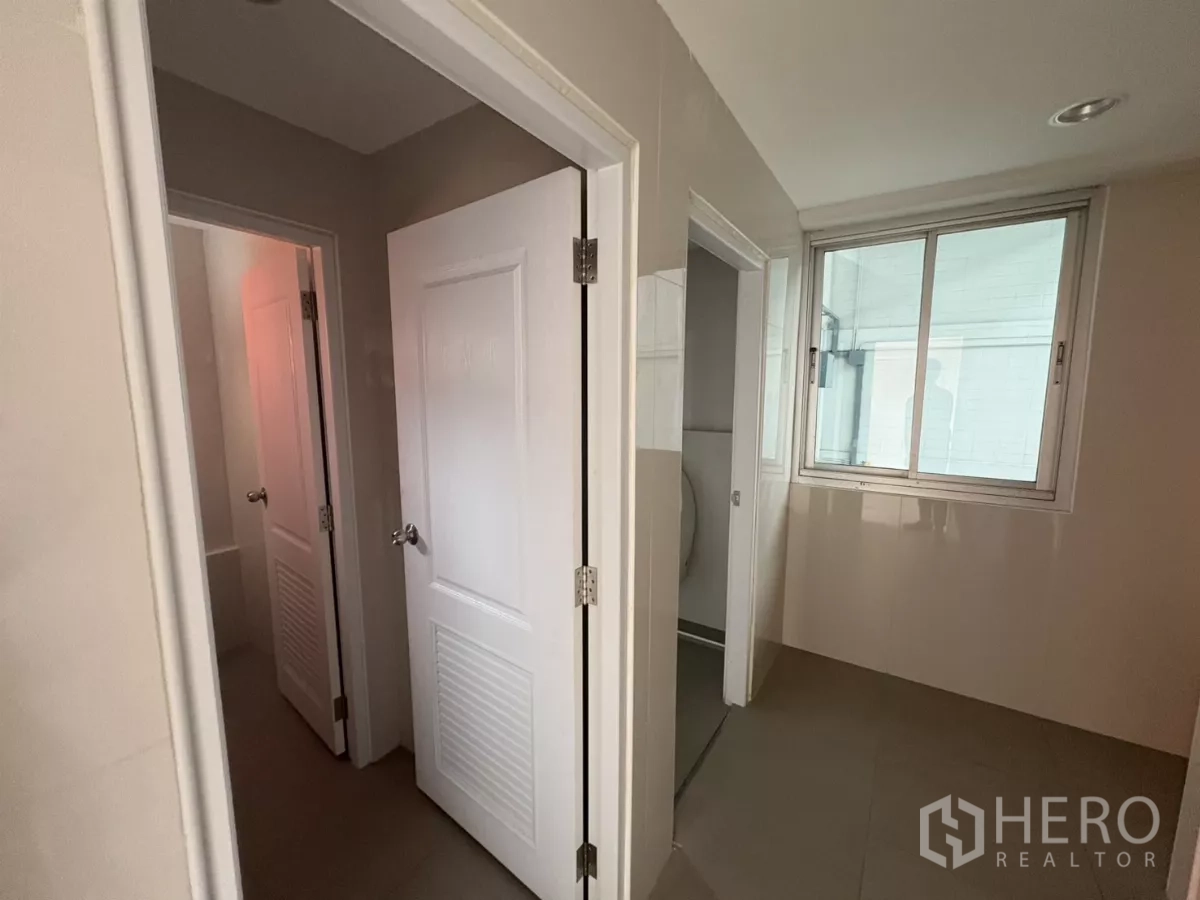 Factory for rent in Bang Phli, Samut Prakan - Office corridor leading to restrooms and utility room with sliding window.