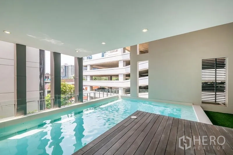 Townhouse for rent in Khlong Toei, Bangkok - Covered private swimming pool with wood deck and open city views.