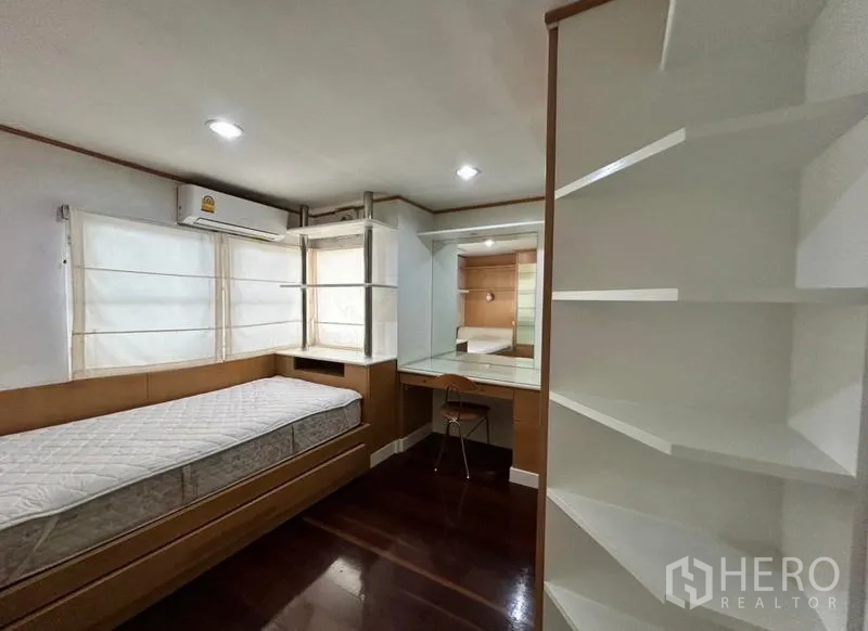 Home Office for rent in Suan Luang, Bangkok - Bedroom with single bed, built-in desk, shelves and corner window.