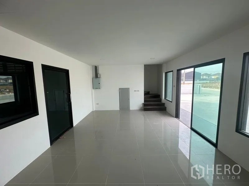 Factory for rent or sale in Bang Bua Thong, Nonthaburi - Open‑plan office with sliding glass entry and staircase leading to the second floor.