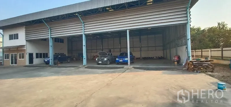 Warehouse for rent in Khlong Luang, Pathum Thani - Three wide roller shutter bays with a parking and loading apron in front of the warehouse.