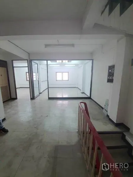 Shophouse for rent in Bang Rak, Bangkok - Open-plan level with tiled flooring, staircase and a glass-partitioned office room inside a shophouse.