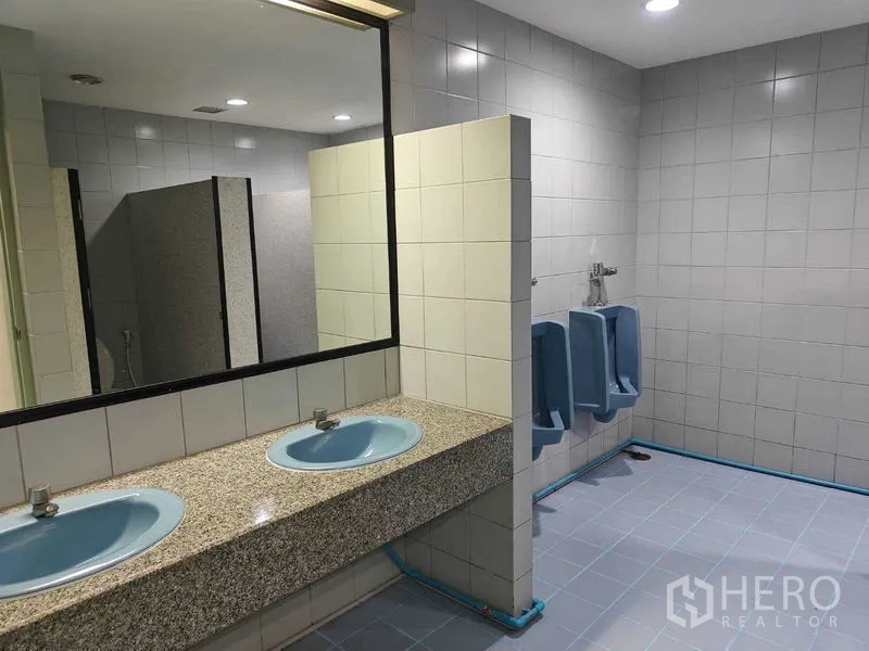 Office Space for rent in Din Daeng, Bangkok - Men’s restroom with twin blue sinks, a large mirror, and urinals.