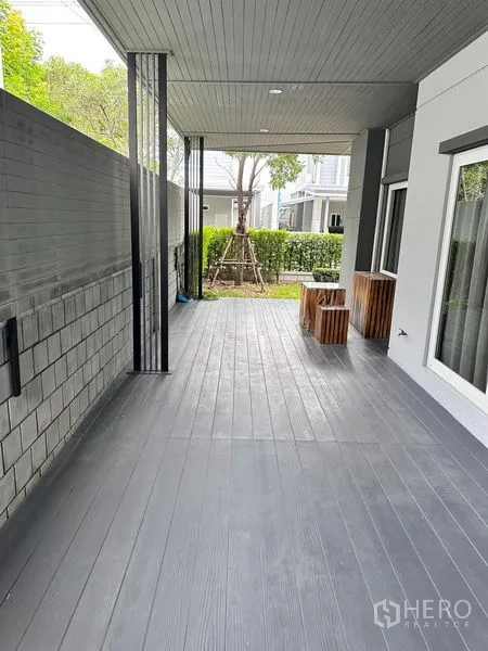 Detached House for sale in Prawet, Bangkok - Covered terrace with grey decking running beside the house.
