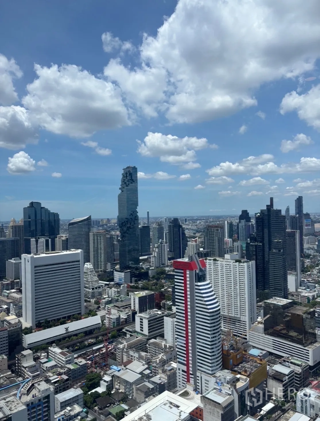 Condominium for rent in Bang Rak, Bangkok - High-rise Bangkok skyline with modern towers under a blue sky.