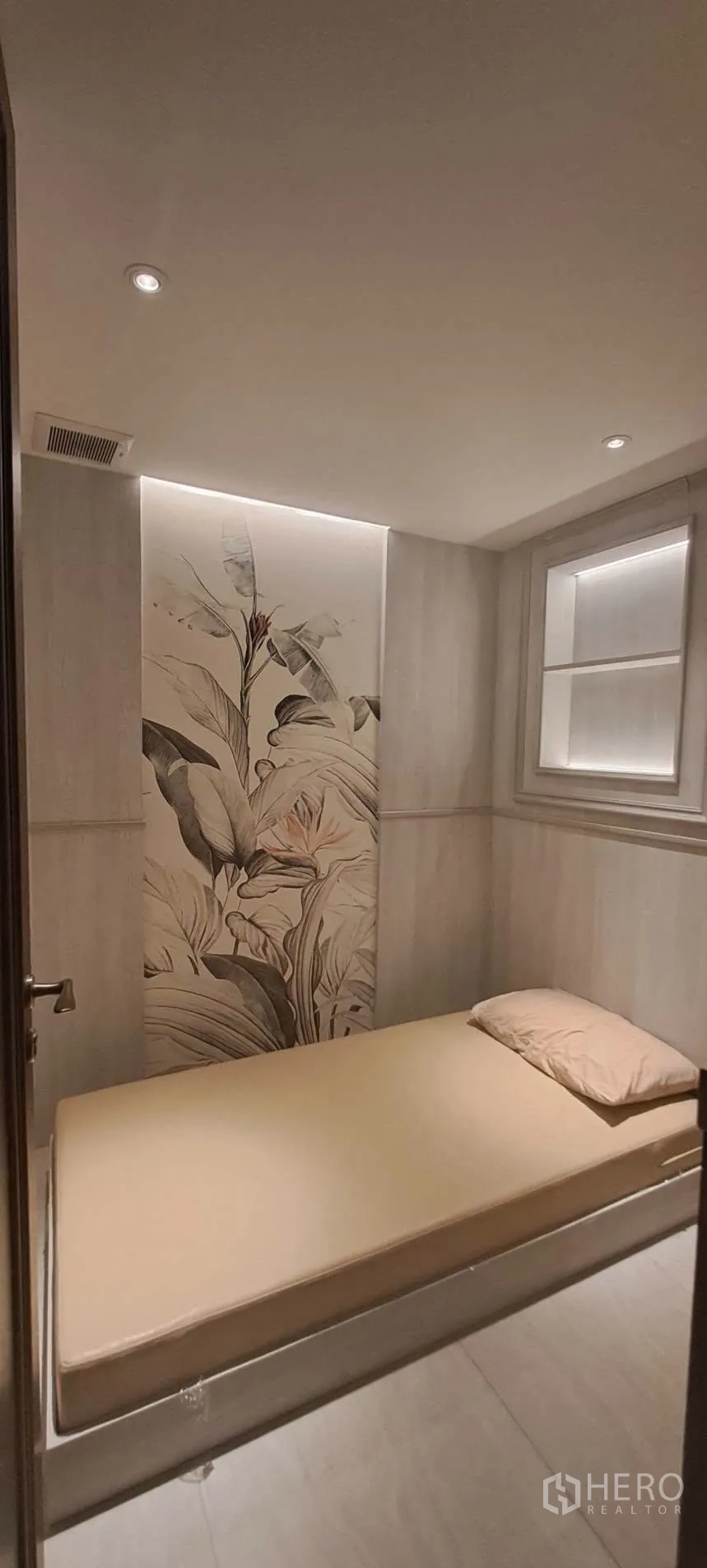 Home Office for rent in Lat Phrao, Bangkok - Compact rest area with single bed, wall art and soft lighting.