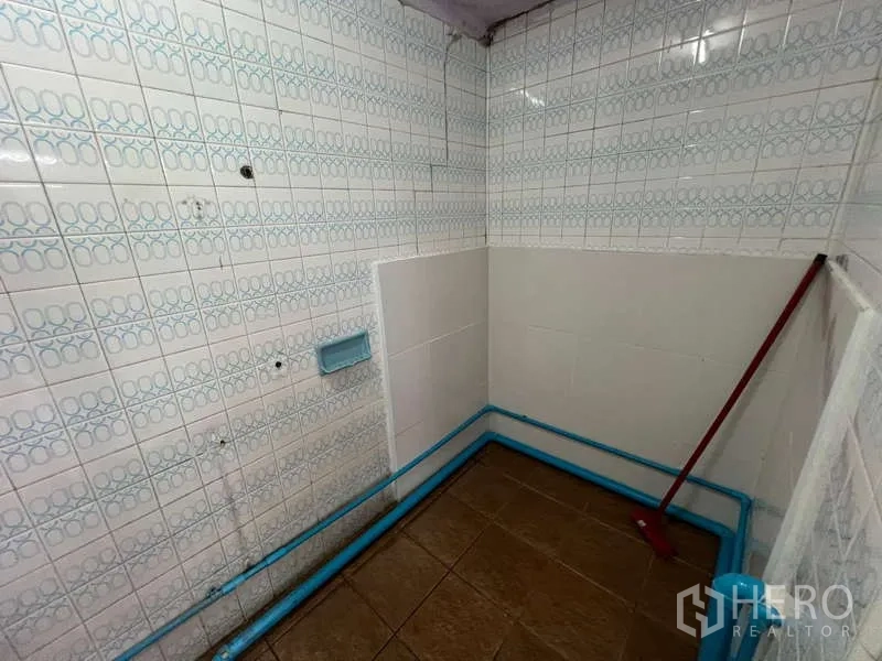 Shophouse for rent in Suan Luang, Bangkok - Small tiled washroom with exposed blue plumbing ready for fittings.