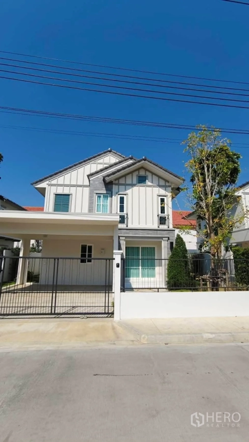 Detached House for rent in Bang Phli, Samut Prakan - Front exterior of two-storey detached house with gated entry, carport and landscaped frontage.
