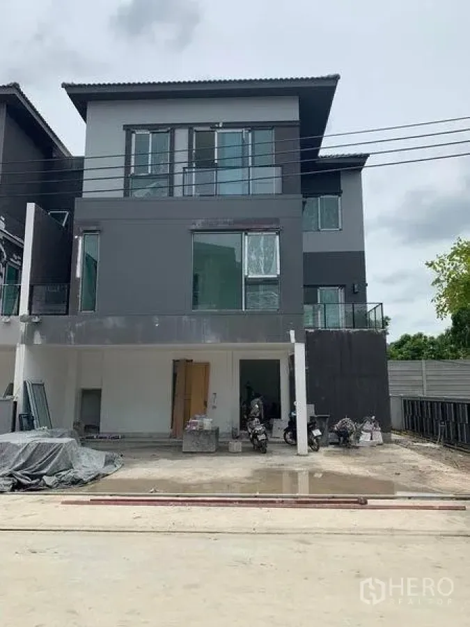 Detached House for sale in Prawet, Bangkok - Front view of a new three-storey house under construction with a carport and wide driveway.