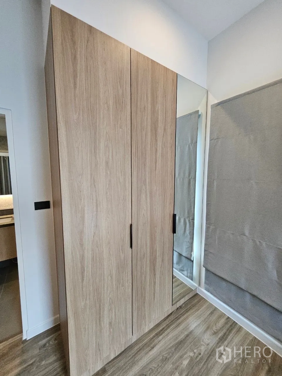Detached House for rent in Bang Kapi, Bangkok - Bedroom corner featuring a tall wooden wardrobe and full-height mirror.