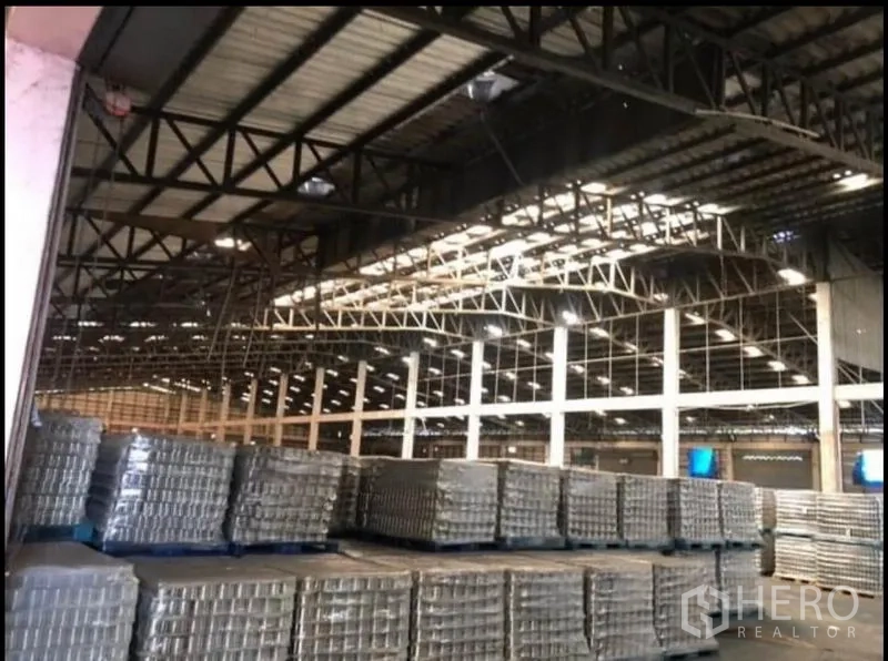 工厂 出租在Bang Khla, Chachoengsao - 近景展示钢梁与天窗，上方为成排托盘堆放区。