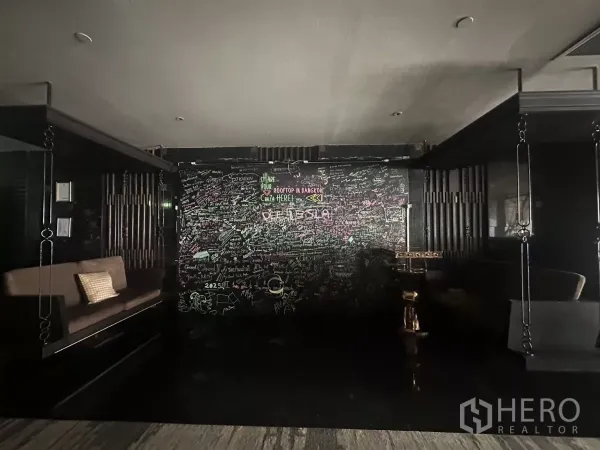Retail Space for rent in Khlong Toei, Bangkok - Dim lounge entrance with a chalkboard graffiti wall and built-in sofas.