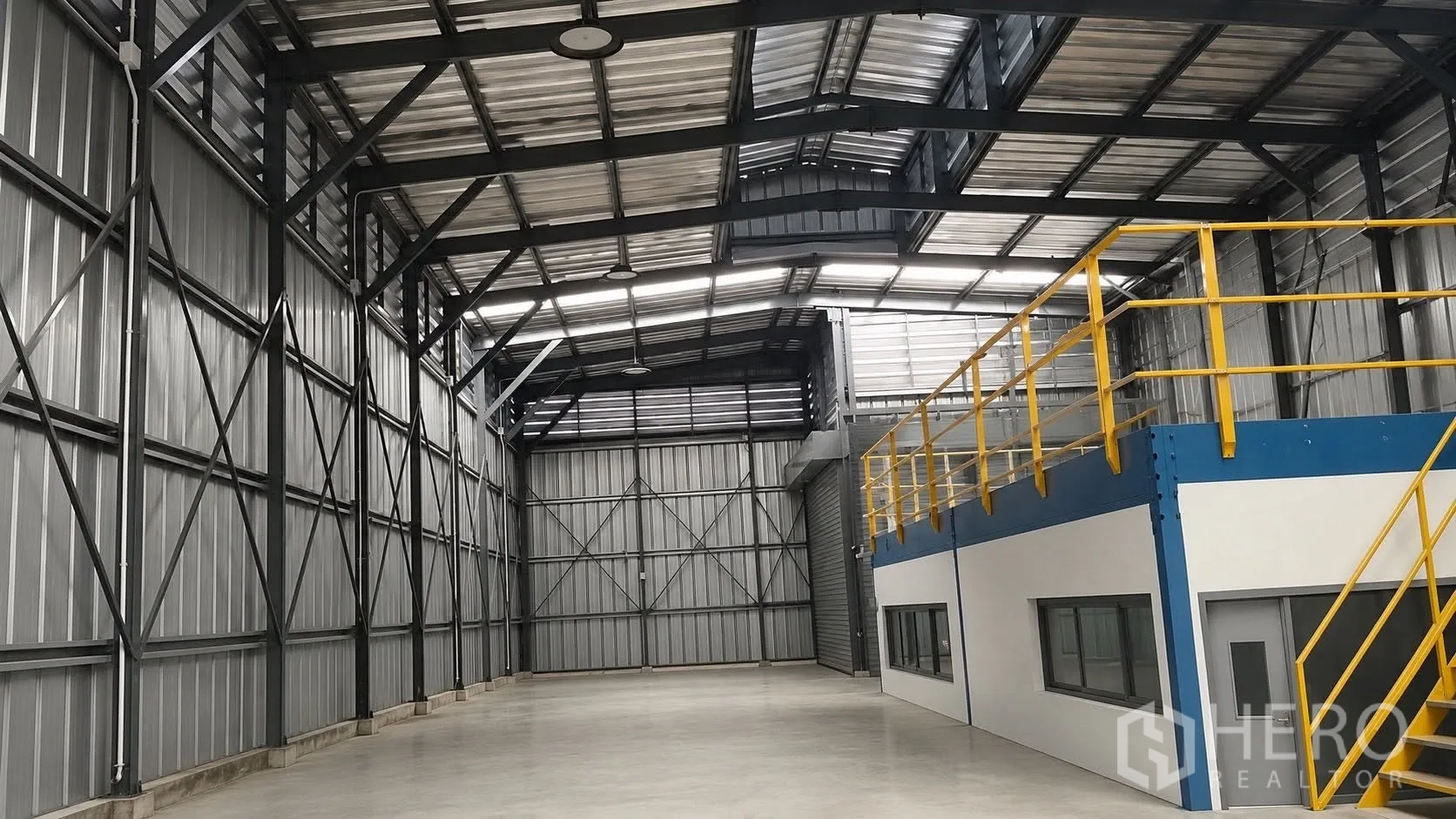 Warehouse for rent in Don Mueang, Bangkok - Steel-frame warehouse interior with high ceiling, concrete floor, mezzanine office and a roller shutter door.