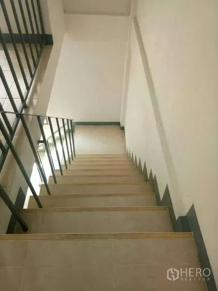 Shophouse for rent in Bang Na, Bangkok - Internal staircase with metal handrail and non-slip steps inside the shophouse.