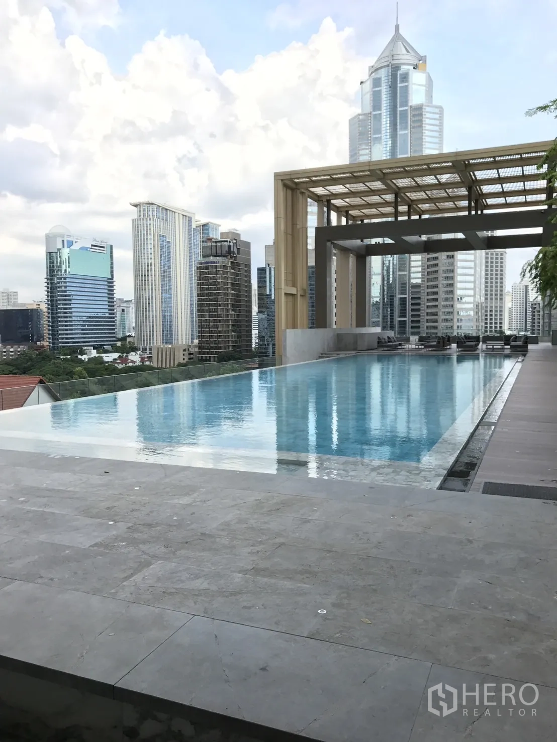 Condominium for rent in Pathum Wan, Bangkok - Rooftop infinity-edge swimming pool with city skyline views and a shaded pavilion.
