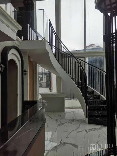 Retail Space for rent - Curved staircase and double-height windows in the retail space.