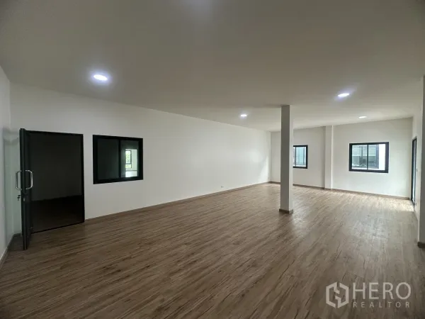 Warehouse for sale in Khlong Luang, Pathum Thani - Upper-floor office area with wood-look flooring, white walls and multiple windows.