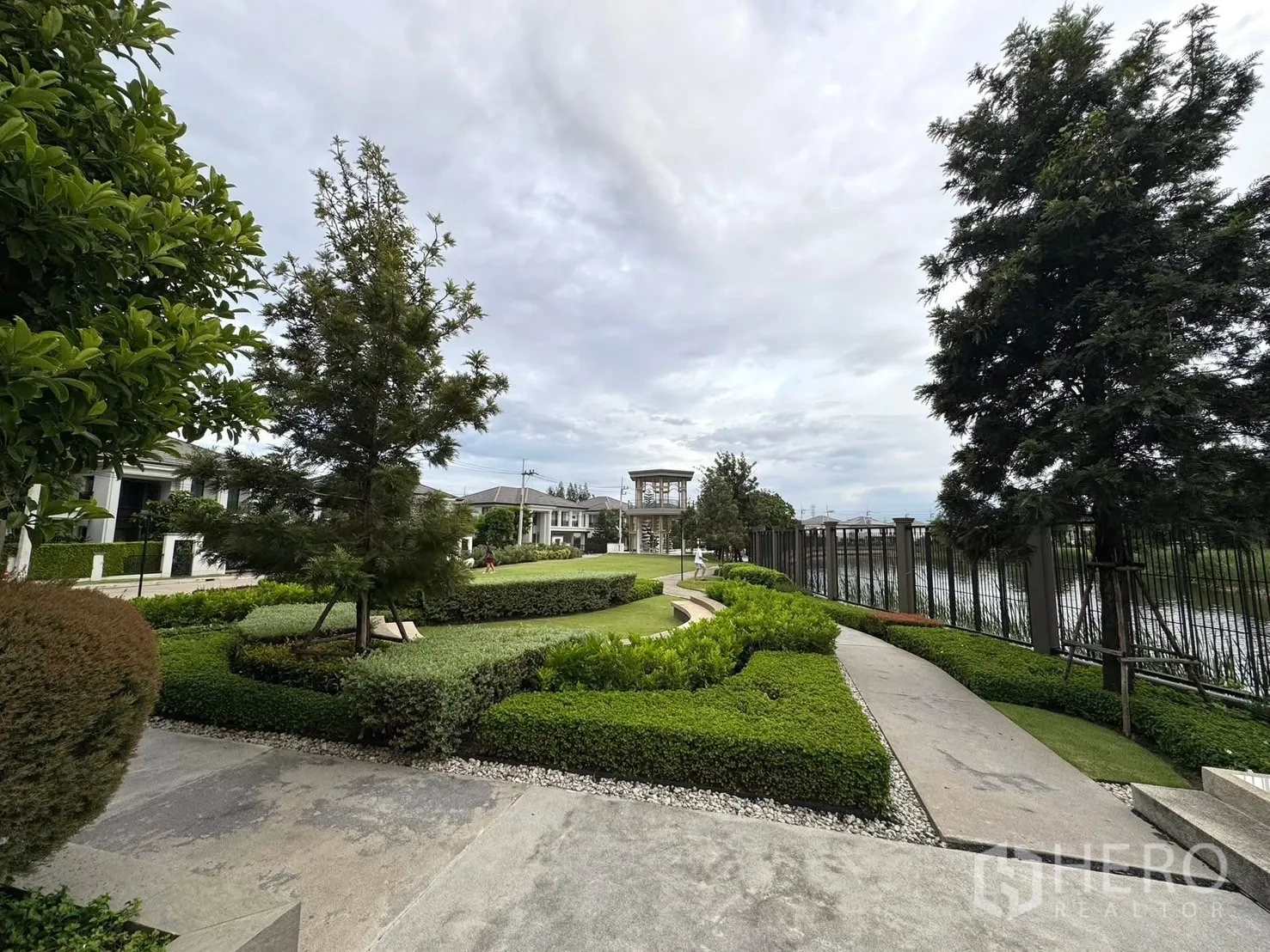 Detached House for sale in Mueang Pathum Thani, Pathum Thani - Garden walkway along the lake within the gated estate.