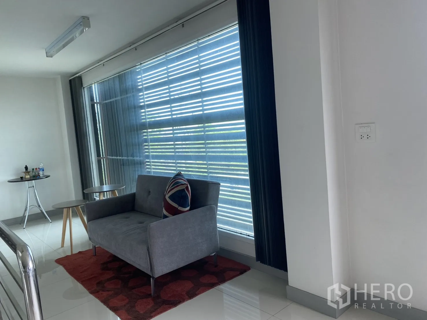 Factory for sale in Khlong Luang, Pathum Thani - Upstairs lounge corner with a sofa, side tables, and a large window.