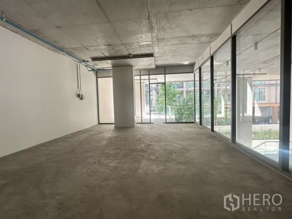 Retail Space for rent - Open-plan layout with full-height glazing and central column, ready for tenant fit-out.