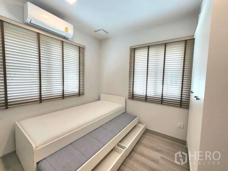 Detached House for rent or sale in Bang Phli, Samut Prakan - Cozy secondary bedroom with trundle bed, built-in wardrobe and dual windows with blinds.