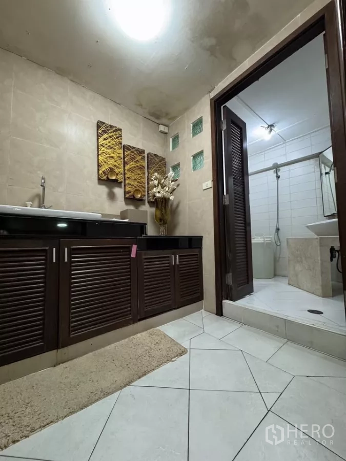 Shophouse for rent in Bang Rak, Bangkok - Bathroom with dark wood vanity and a separate shower room finished in white tiles.