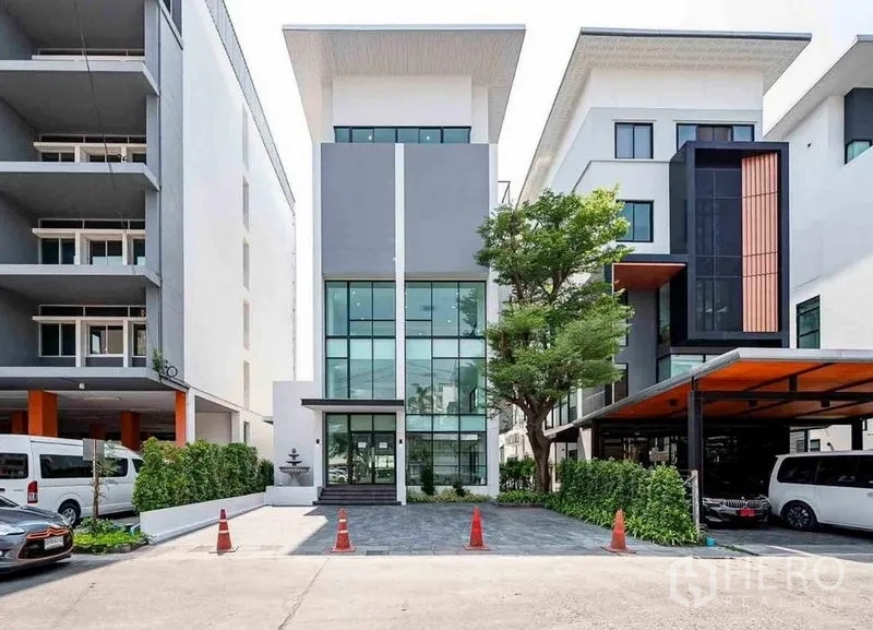 Home Office for rent in Suan Luang, Bangkok - Modern five-storey home office exterior with glass facade, driveway and shade tree in Suan Luang, Bangkok.