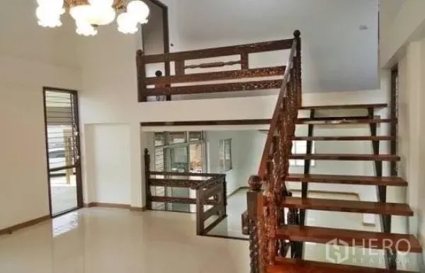 Home Office for rent in Chatuchak, Bangkok - Double-height living area featuring an ornate wooden staircase and chandelier.