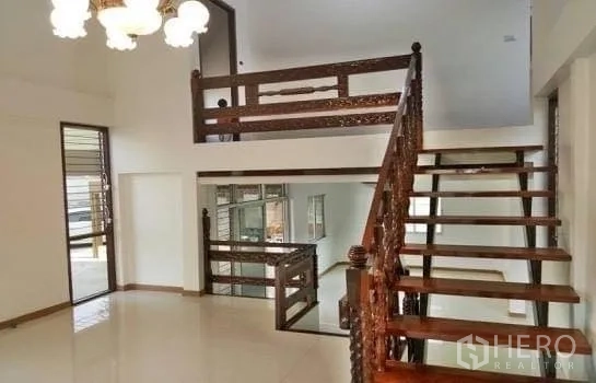 Home Office for rent in Chatuchak, Bangkok - Double-height living area featuring an ornate wooden staircase and chandelier.