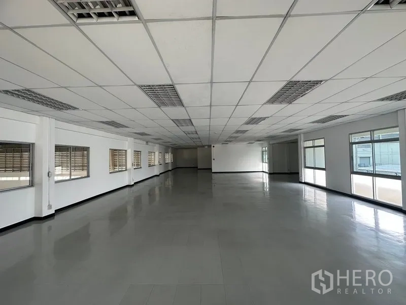 Factory for rent in Phra Nakhon Si Ayutthaya - Open-plan office area with grid ceiling, tiled floor, and windows on both sides for natural light.