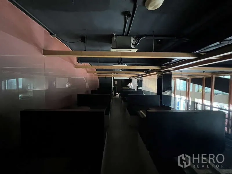 Shophouse for rent or sale in Khlong Toei, Bangkok - Mezzanine level with rows of booth seating under a dark exposed ceiling.