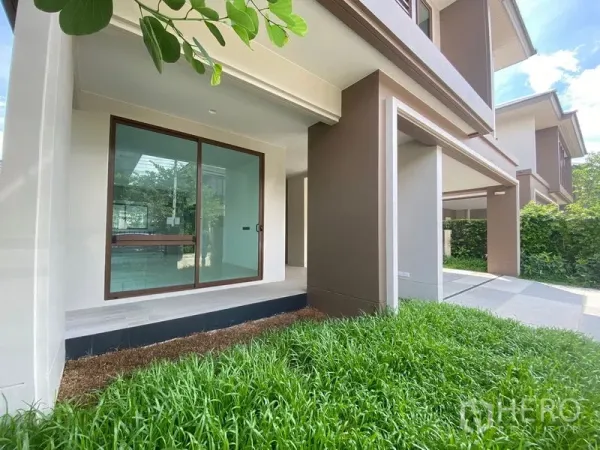 Detached House for rent in Bang Kapi, Bangkok - Covered front porch with sliding glass door opening to a small green lawn.
