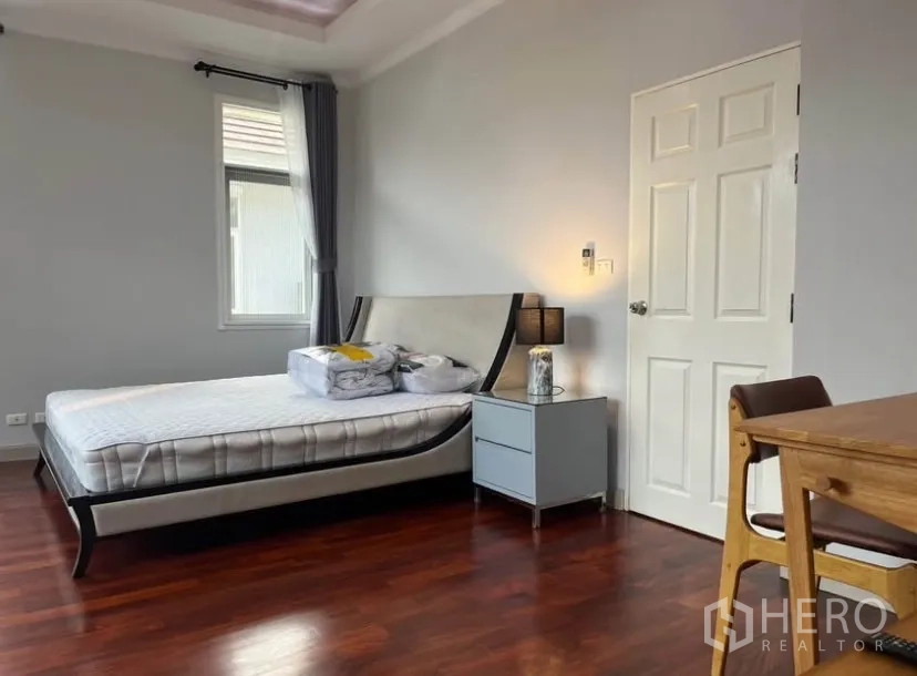 独立式住宅 出租或出售在Lat Phrao, Bangkok - 主卧宽敞，配床与床头灯，木地板。