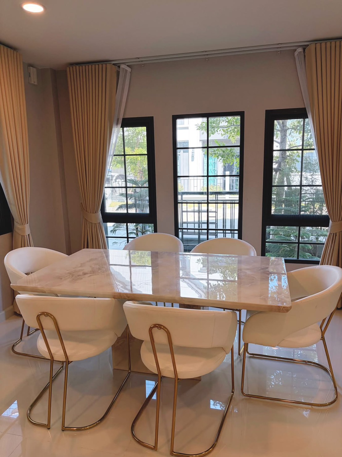 Detached House for rent in Bang Phli, Samut Prakan - Dining area with marble-top table, six white chairs and black-framed windows.