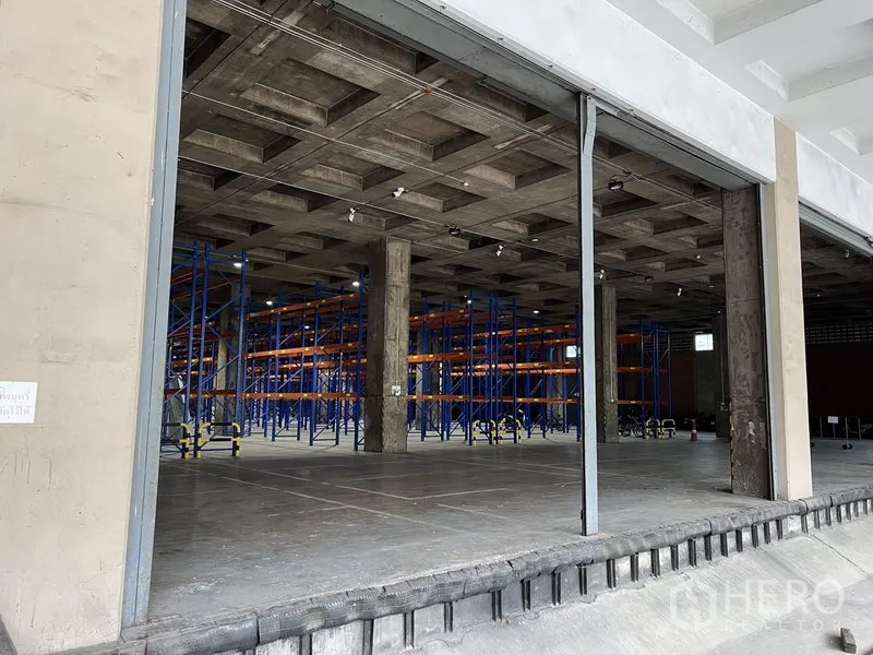 Warehouse for rent in Chatuchak, Bangkok - Industrial interior featuring orange-and-blue selective pallet racking and concrete columns in a Bangkok warehouse.