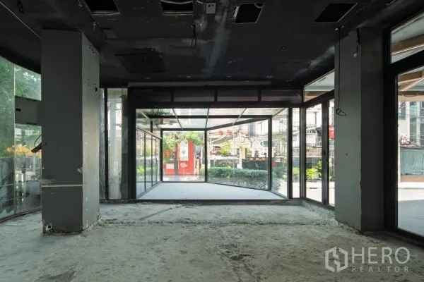 Retail Space for rent - Bright front zone with wraparound glass walls looking out to greenery and the road.