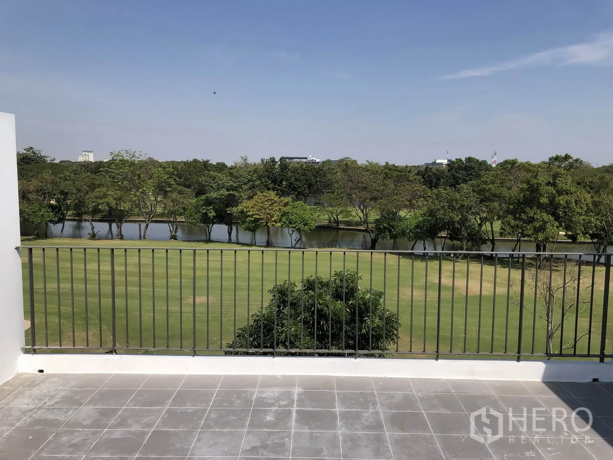 Townhouse for rent in Bang Kapi, Bangkok - Spacious upper terrace with metal railing facing green fairway and lakeside scenery.