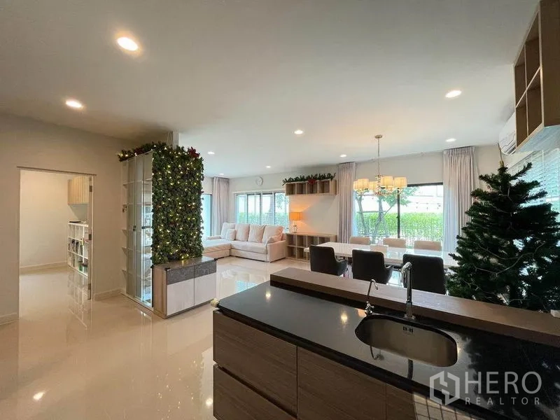 Detached House for sale in Pak Kret, Nonthaburi - Open kitchen with island overlooking spacious living and dining areas with large windows.